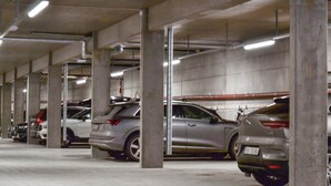 A multi-level parking garage with concrete pillars and overhead lighting.