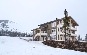A multi-story hotel with balconies, a ski slope in the background, and a snowy landscape. - Beautiful apartment in Trysil (Trysil)