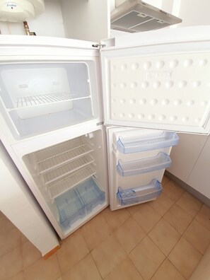 Een open koelkast met een vriesvak, een waterdispenser en een ingebouwde ijsmachine.
