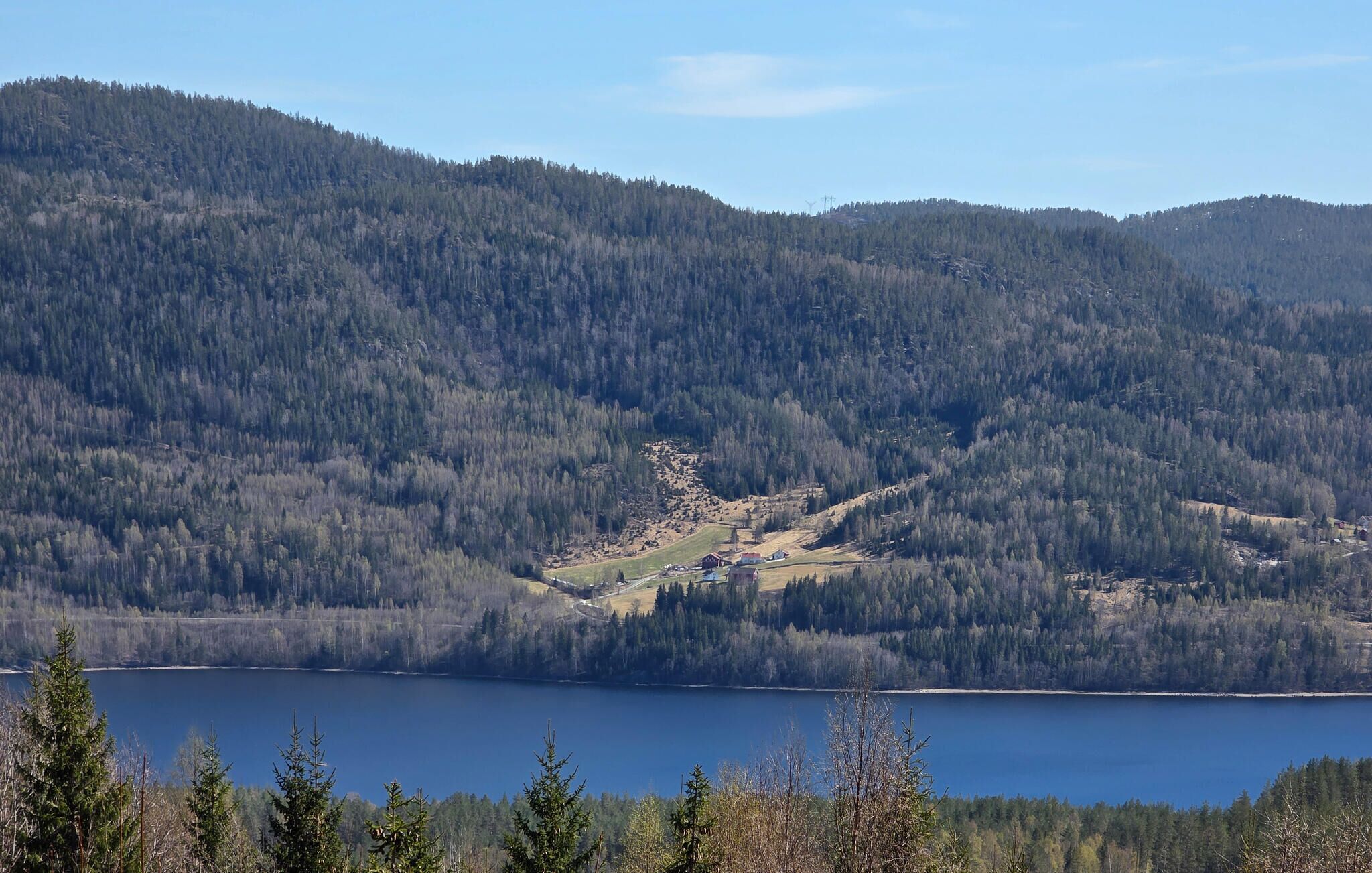 A mountainous landscape with a lake and a small settlement.