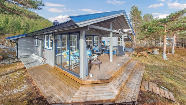 Une cabane dotée d’une terrasse, d’un espace salon extérieur et d’un foyer.