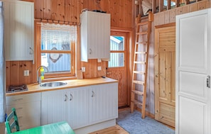 Een compact keuken met een spoelbak, kastjes en een raam met uitzicht.