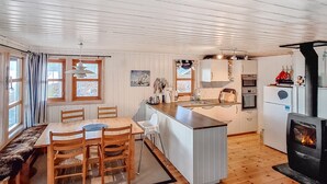 Une cuisine chaleureuse, aménagée dans un style rustique, avec un îlot central, une table à manger en bois et des chaises.