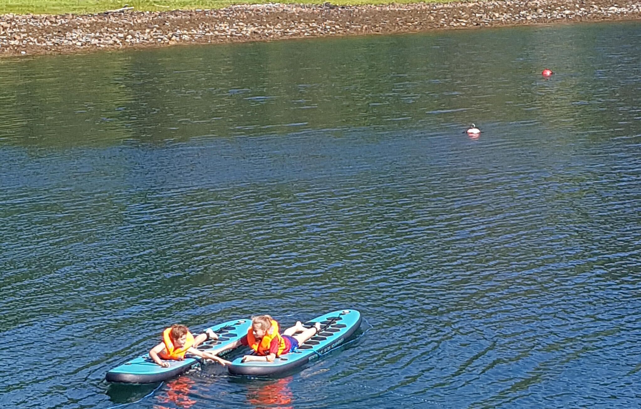 Deux personnes dans un kayak sur une étendue d’eau calme.