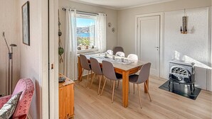 Een eetgedeelte met een houten tafel, stoelen en een oude fornuis.