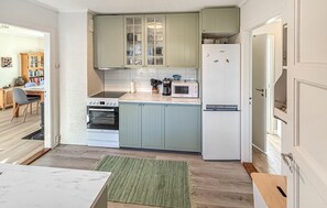 A compact kitchen with a stove, oven, microwave, and refrigerator.