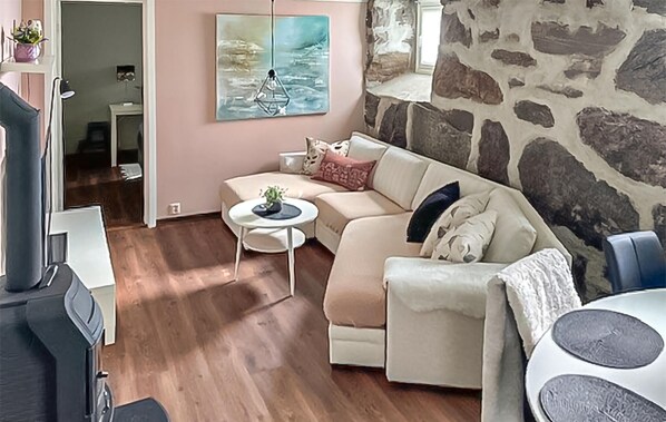 A living room with a sofa, a small round table, and a stone wall.