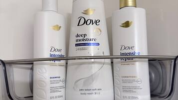 A bathroom shelf with Dove skincare products including deep moisture lotion, intensive repair, and conditioner.