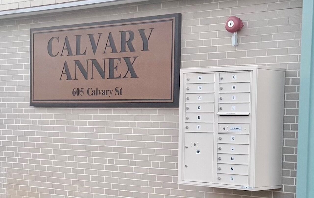 A mailbox with a sign above it that reads 'CALVARY ANNEX 605 Calvary St.'
