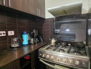 A kitchen with a gas stove, a kettle, a blender, and a coffee maker. - Upscale 3BR Apt in Cusco,Gateway to Machu Picchu , Best Area (Cusco)