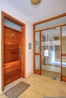 A wooden door with a handle, a glass door with a sign reading '500 Highgrove,' and a doormat on the floor.