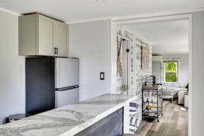 Une cuisine moderne dotée d’un plan de travail en marbre, d’appareils électroménagers en acier inoxydable et d’un design minimaliste.