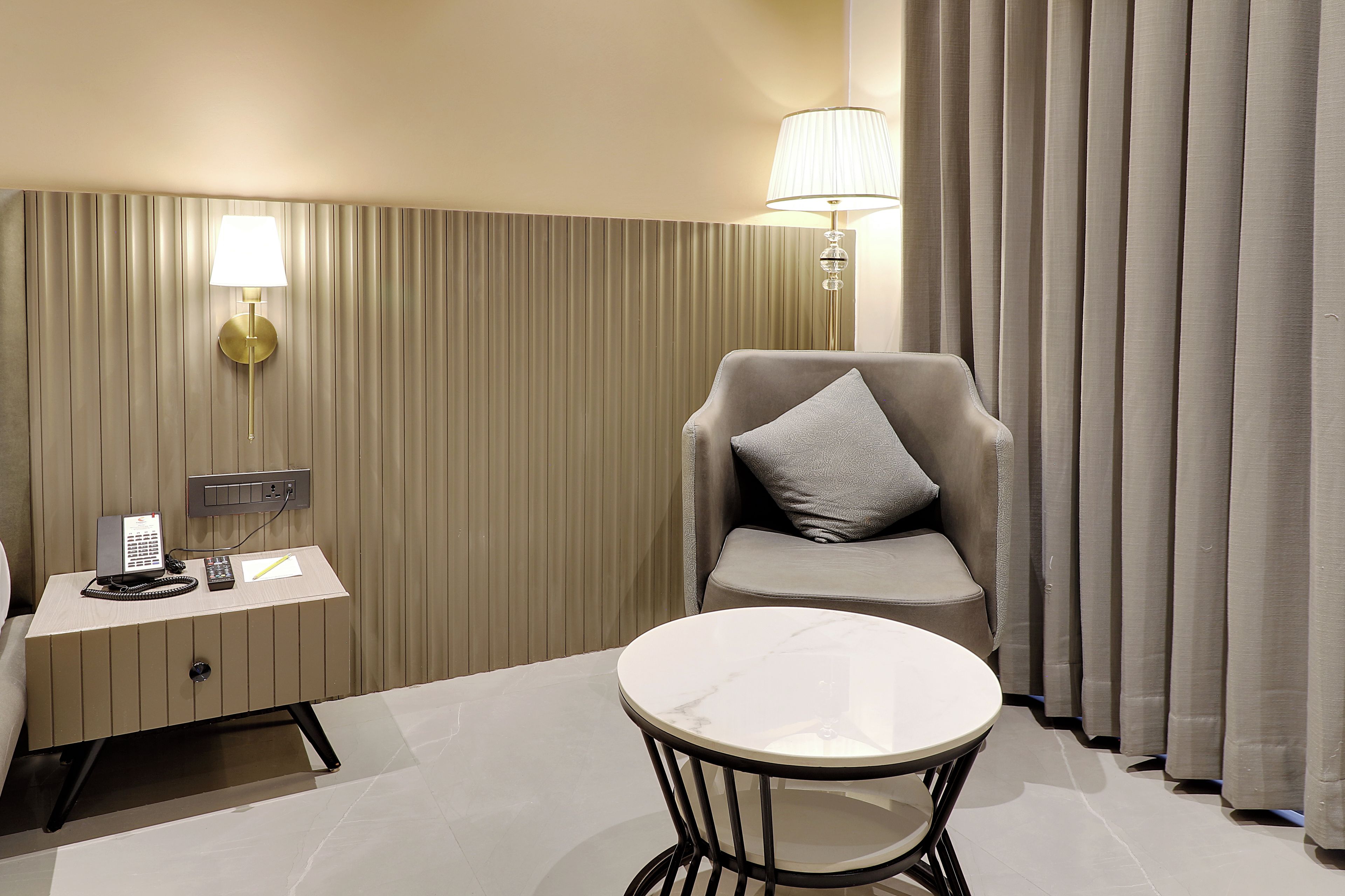Una habitación de hotel con escritorio, silla y una pequeña mesa redonda.