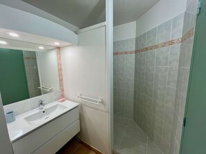 Ein Badezimmer mit Waschbecken, Spiegel und Dusche.
