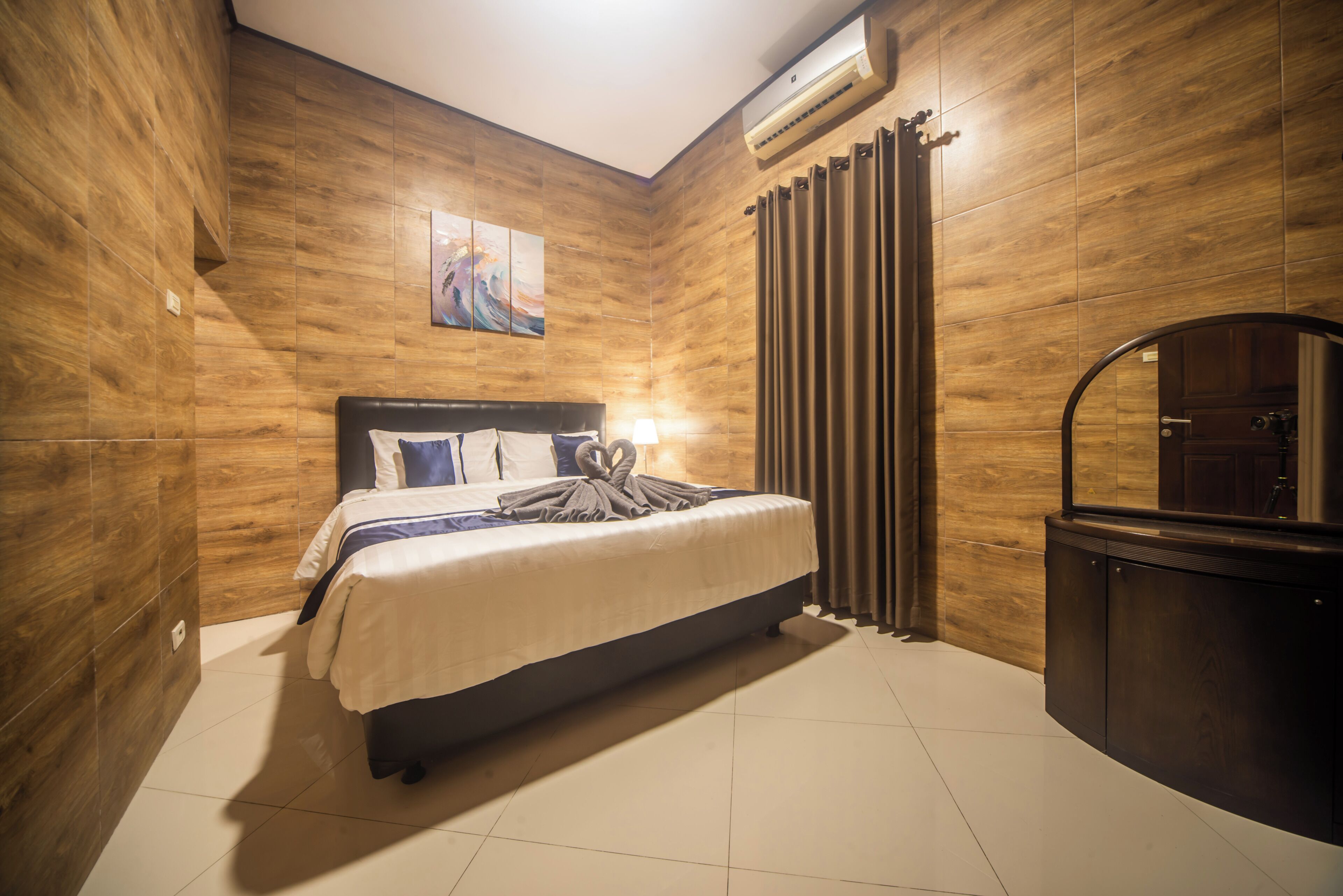 Une chambre à coucher avec un lit, une table de chevet, un miroir et un mur en bois.