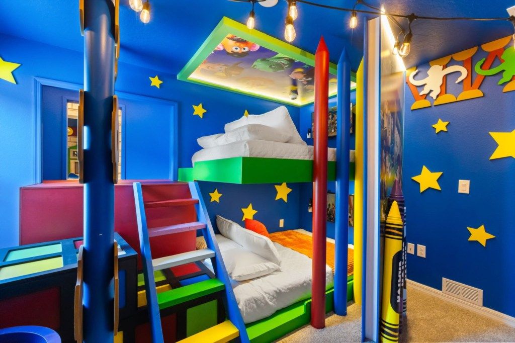 Une chambre d'enfant avec un lit superposé, un bureau et un espace de jeux.