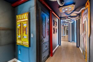 A corridor with doors, a red pipe, and a ceiling with a unique design. - 8 BD / 5.5 BA / Windsor Cay 1012 BP (Clermont)