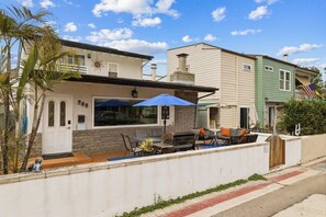 A residential property with a patio, outdoor seating, and a brick wall. - South Mission Beach Home – 3BR, Epic Patio, Rare 3-Car Parking, Steps to the Sand (San Diego)