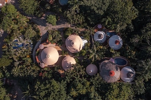 Ein Luftbild eines Resorts mit mehreren kuppelartigen Bauten, umgeben von dichtem tropischen Grün.