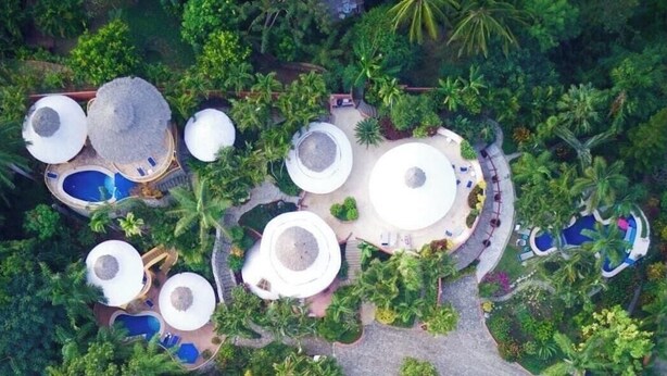 An aerial view of a resort with multiple circular structures, some with pools, surrounded by dense greenery. - Casa Rana Verde: Marvelous 3-bedroom villa with AC in vibrant Sayulita (Sayulita)