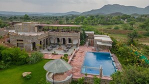 Una villa con piscina, mobiliario de exterior y vistas del paisaje circundante.
