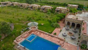 Un edificio tradicional con piscina, zona de estar al aire libre y vistas del paisaje circundante.