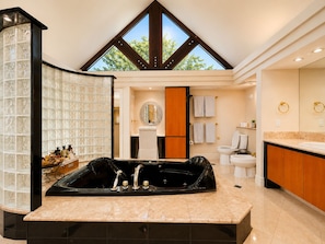A modern bathroom with a freestanding bathtub, a large mirror, and a skylight.