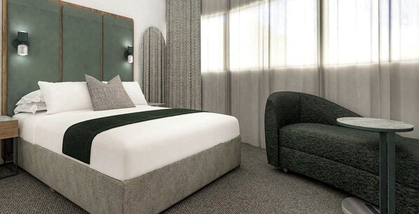 Ein Hotelzimmer mit einem großen Bett, einer kleinen Couch, einem runden Tisch und einem Kopfteil mit Wandleuchten.