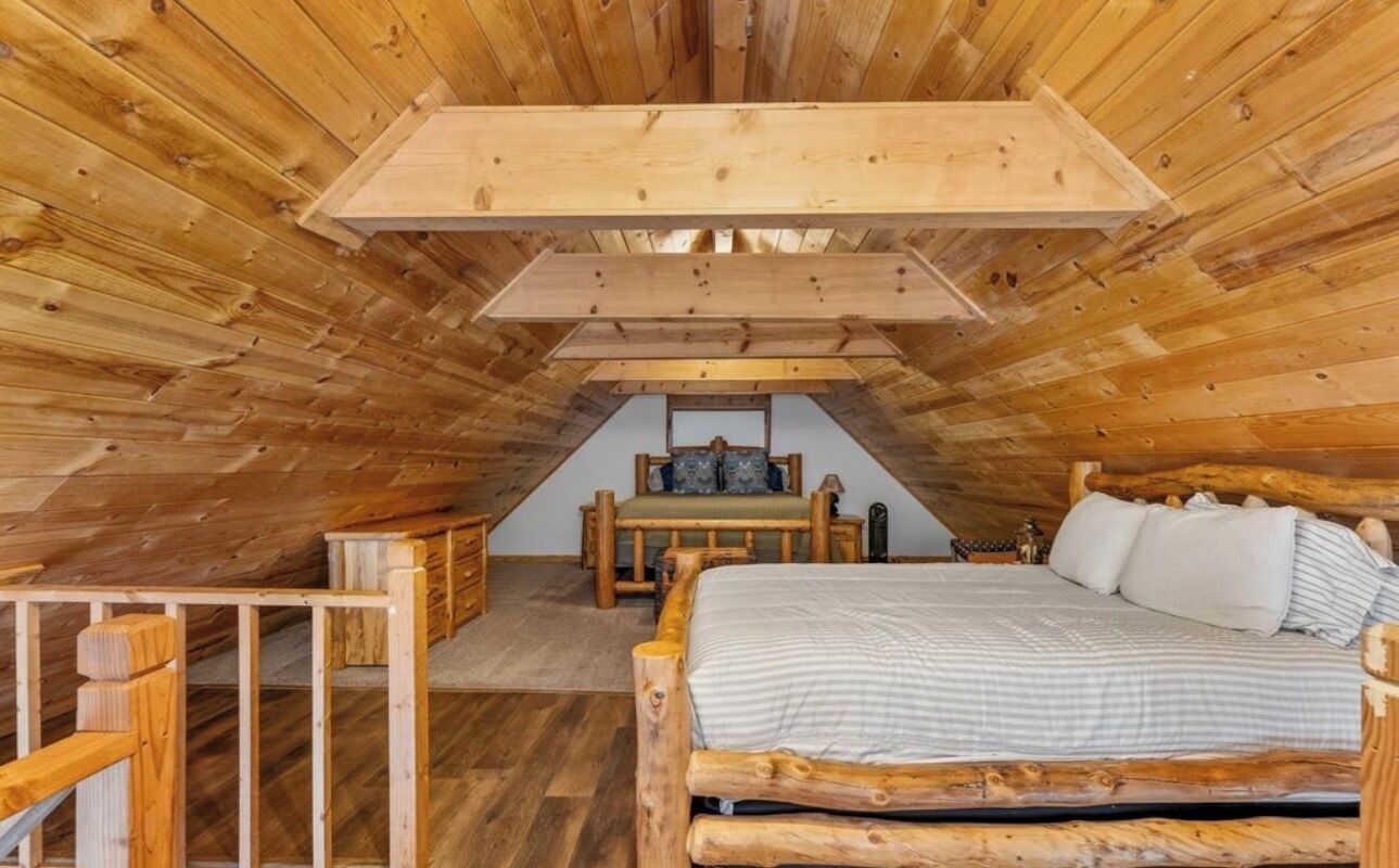 A wooden interior with a bed, a bench, and a table.