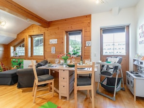 Une charmante cabane en bois comprenant un coin repas, un espace de jeux et une petite cuisine.