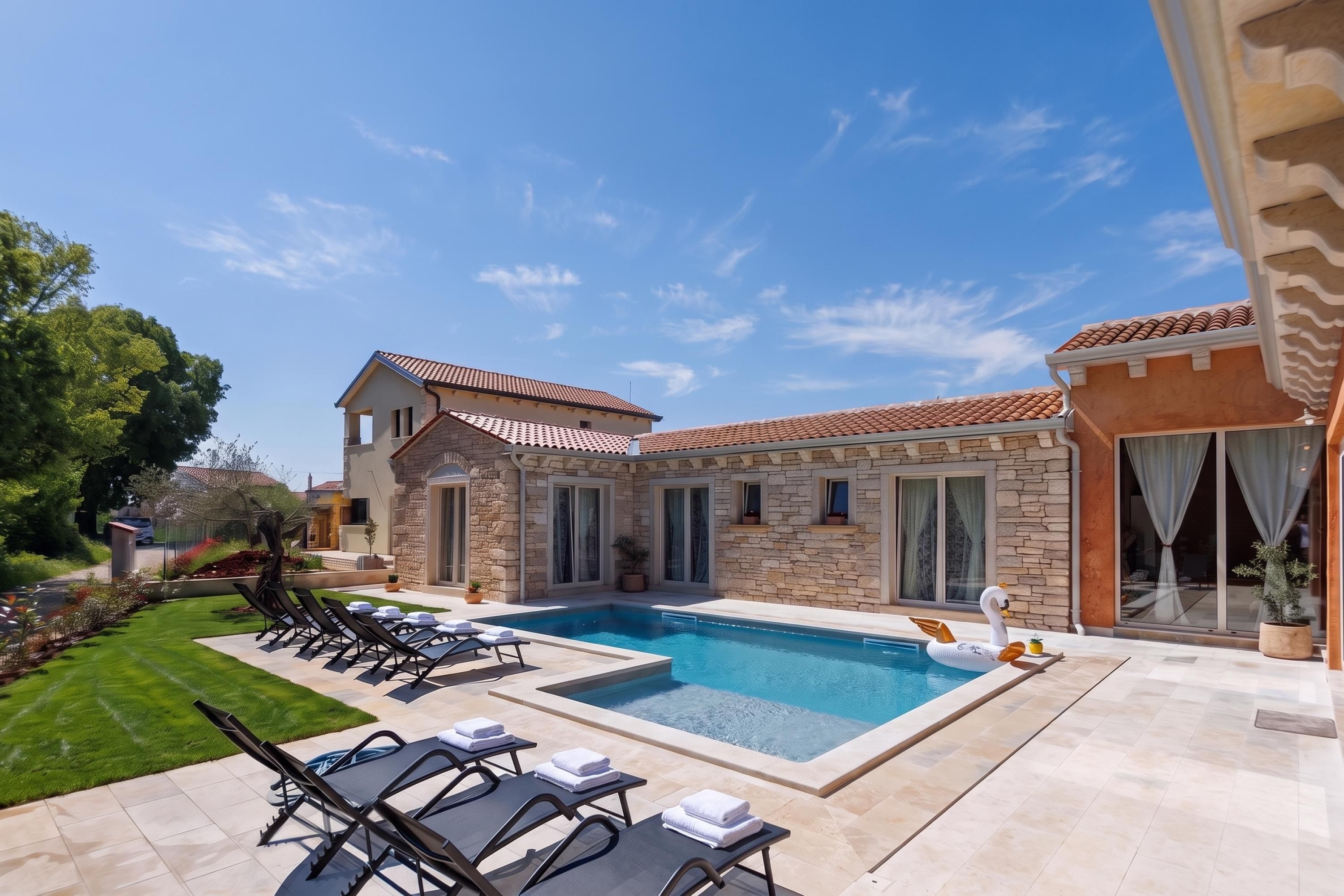 Una casa moderna con piscina, fachada de piedra y jardín cuidado.