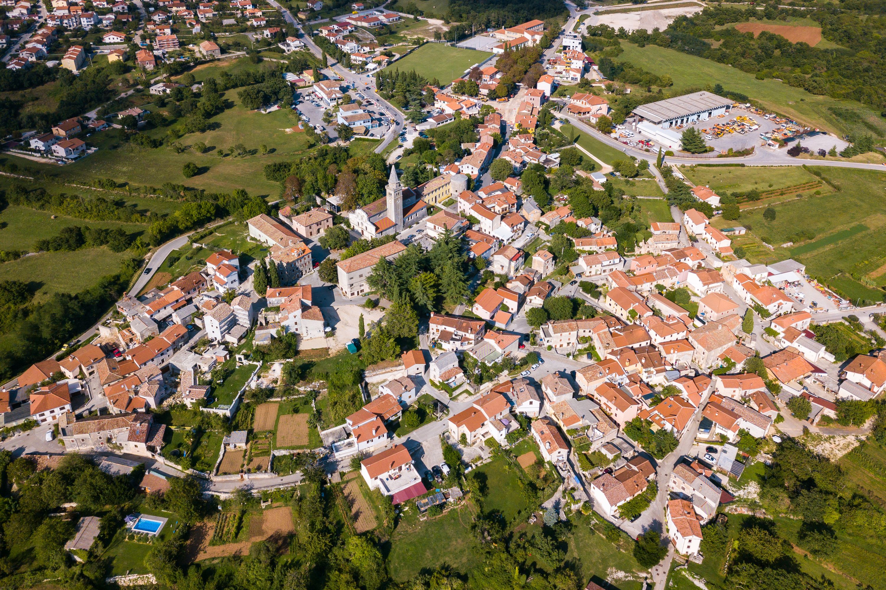 Vista aérea de un área residencial con casas, calles y espacios verdes.