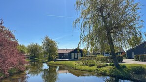 En lugn och vacker plats vid floden med ett hus, ett träd och en klar himmel.