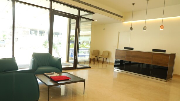 Un moderno vestíbulo de hotel con una recepción, zona de estar y grandes ventanales.