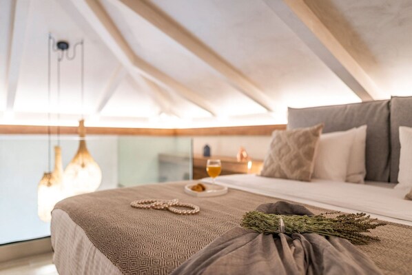 Ein Schlafzimmer mit einem Bett, einem Nachttisch mit einem Weinglas und einer Pendelleuchte.