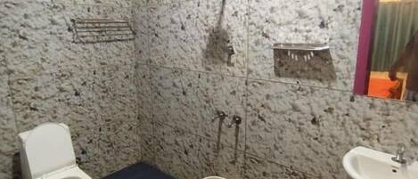 A bathroom with a toilet, a sink, and a shower.