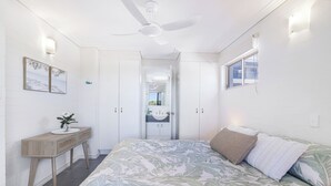 A bedroom with a bed, a desk, a wardrobe, and a ceiling fan. - 2 Bedroom Unit with Beach & Golf at your doorstep! (Bargara)