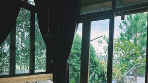 Un dormitorio con una cama grande, cabecera de madera y vistas al exterior.