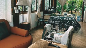 Una habitación acogedora con un sofá, un plaid de piel sintética y una manta con motivos navideños.