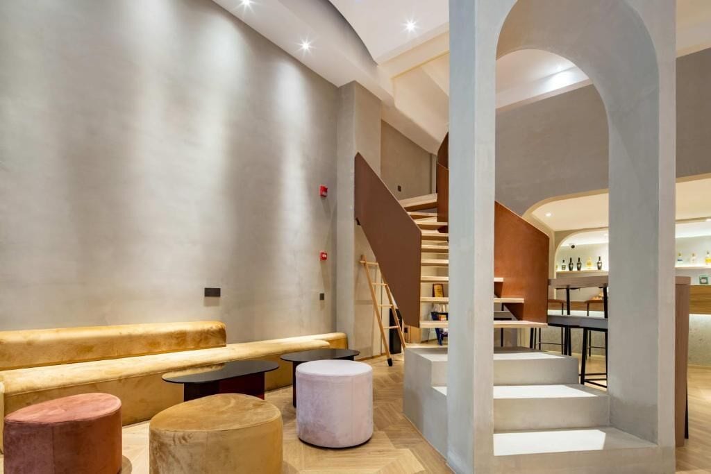 Un interior moderno con una zona de estar, una escalera y una barra.