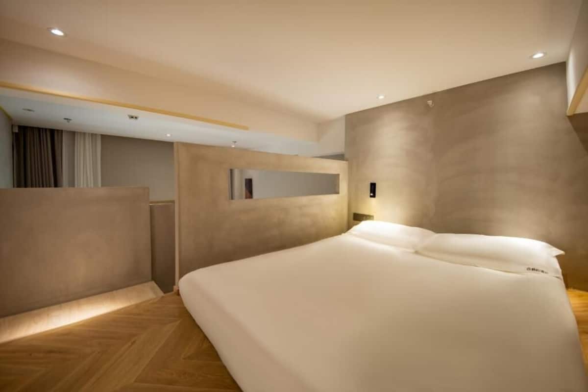 Un dormitorio moderno con una cama grande, luces empotradas en el techo y un diseño minimalista.