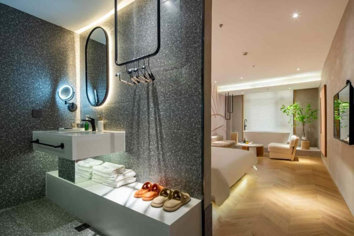 Un baño moderno con encimera de granito, espejo y toallero.