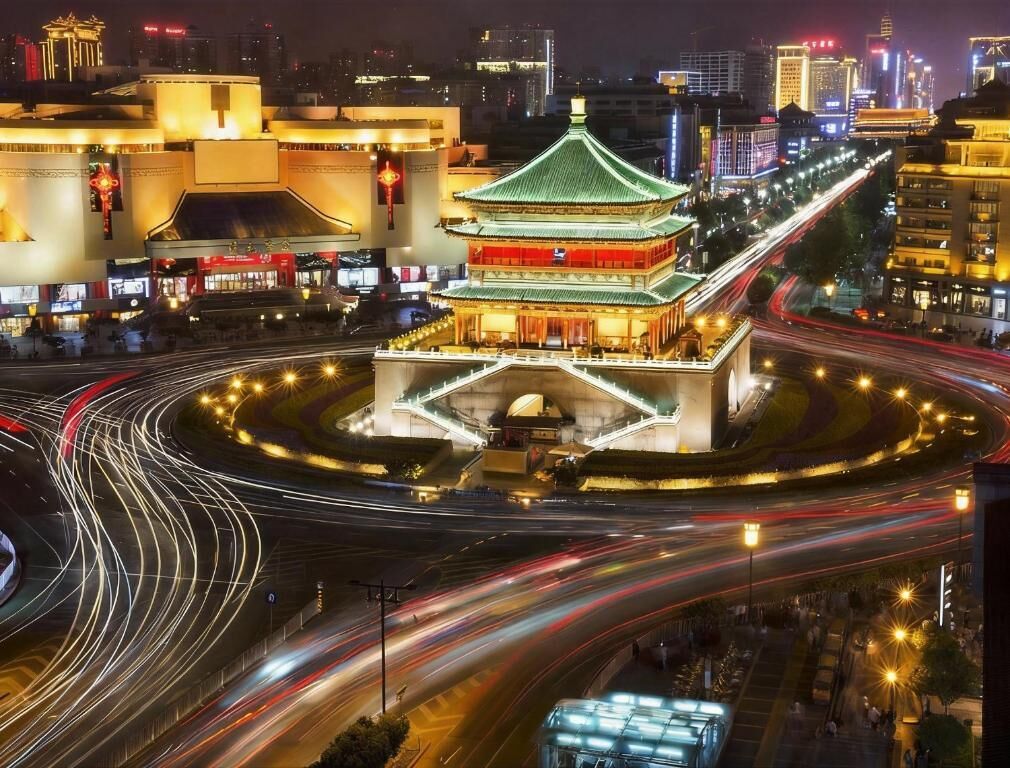 A traditional building with a green roof and multiple levels, surrounded by a roundabout with light trails indicating traffic.