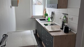 Eine moderne Küche mit Backofen, Spüle und Fenster.