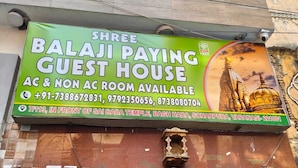 A signboard for a guest house advertising AC and non-AC rooms, with contact numbers and location details. - Shree Balaji Paying Guest House (Varanasi)