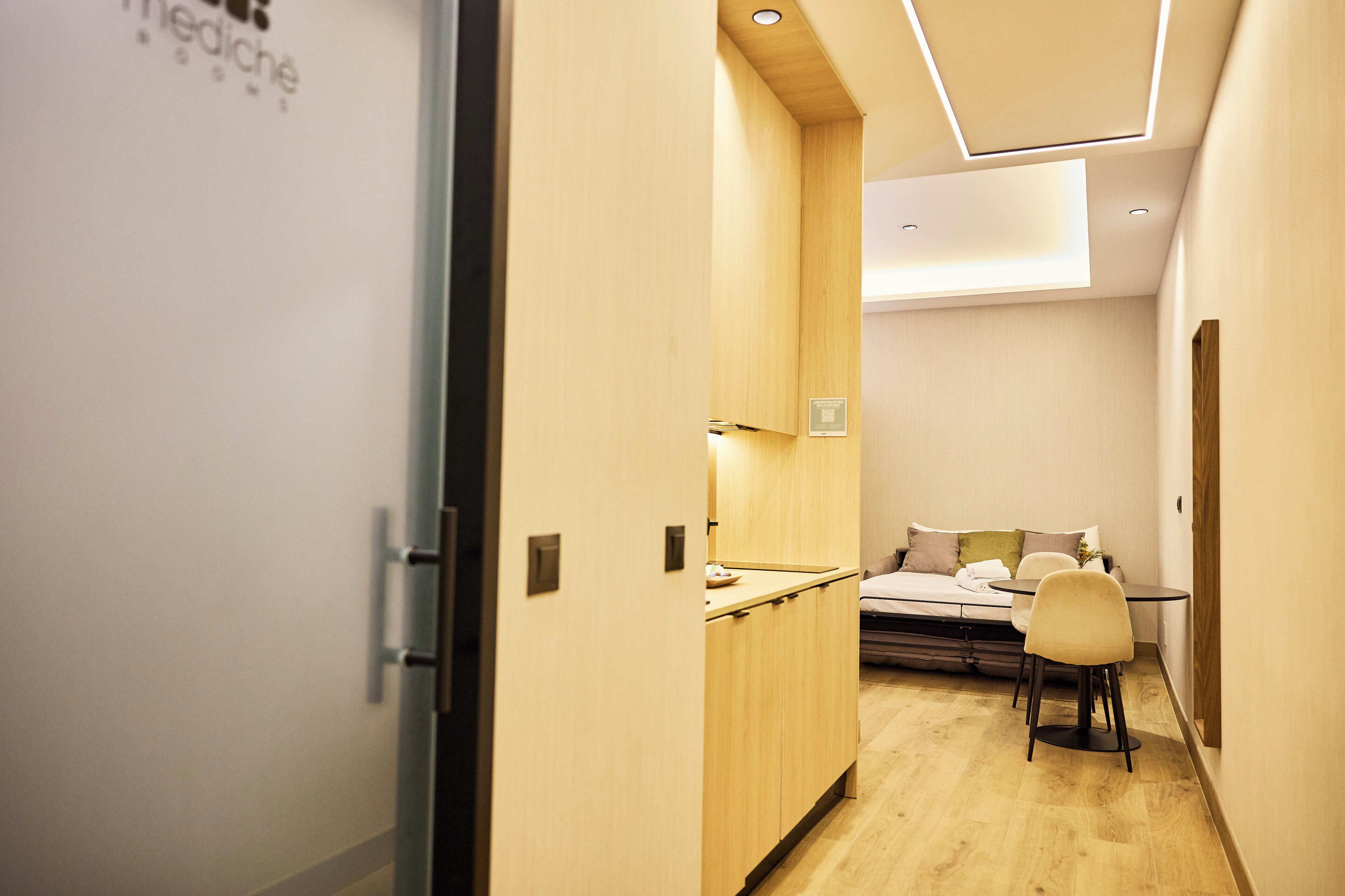 A hotel room with a bed, a desk, and a chair.