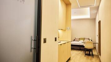 A hotel room with a bed, a desk, and a chair.