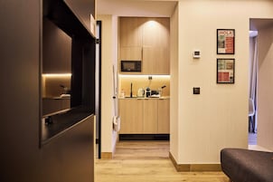 A modern kitchen with wooden cabinets, a microwave, and a coffee maker.