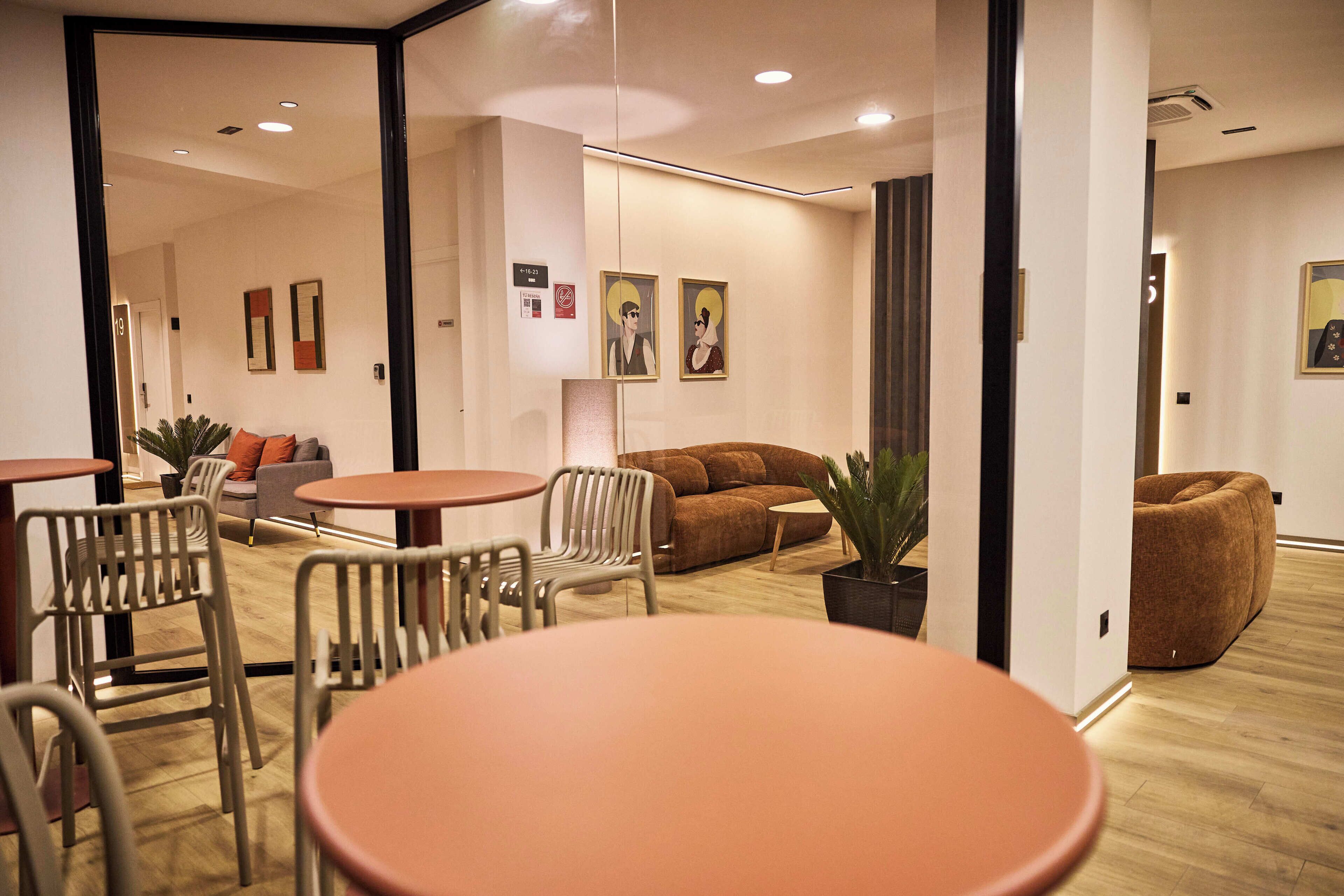 A modern interior with a wooden floor, a brown sofa, a round table, and a white chair.