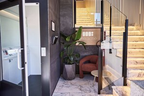 Un hall de hotel con una recepción, una escalera y un área de descanso.